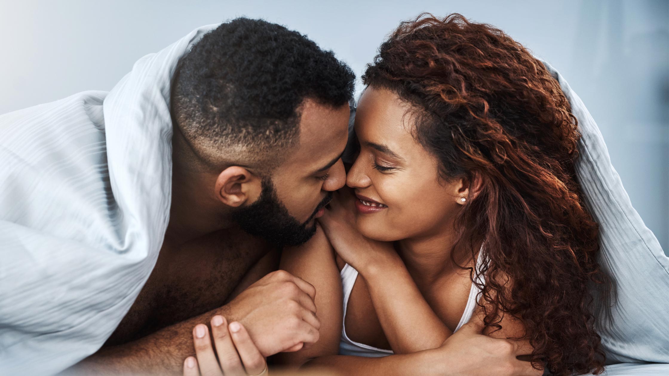 Couple in bed. Discover the 8 foods that can increase your sex drive.